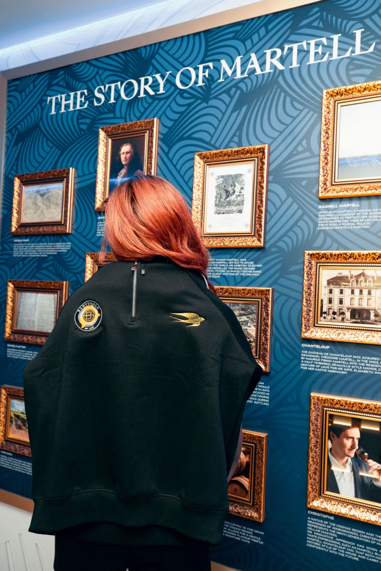 A Bantu Gold × Martell jacket worn in front of the Story of Martell wall